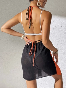 Close-up of knit beach dress with halter back, orange trim, and elegant tie details