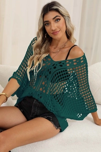 Detail of dark green hollow crochet bikini cover-up showing knit texture and batwing sleeves