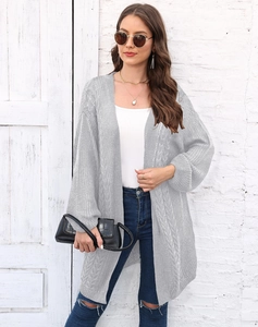 Detail of cable knit pattern on women's long light gray cardigan with ribbed cuffs