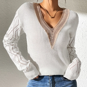 Detail of white knit top showing V-neck with champagne lace trim and hollow crochet texture
