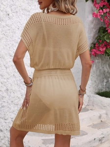 Detail of beige crochet knit cover-up dress showing intricate hollow-out texture on back