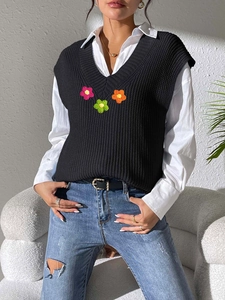 Détail du débardeur en maille col V avec fleurs au crochet sur chemise blanche