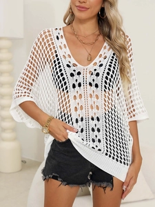 Close-up of white crochet knit texture and deep V-neckline of bohemian beach cover-up