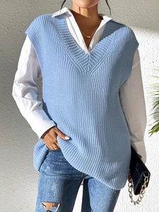 Detail of light blue V-neck knit vest layered over a white shirt with textured weave