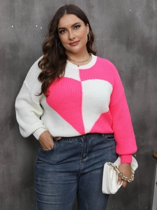 Detail of color-block knit sweater featuring large heart pattern and lantern sleeves