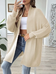 Detail of a beige knit cardigan with a loose open front style and thick textured material
