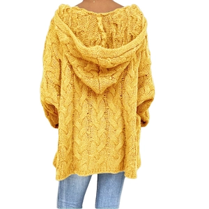 Detalle del tejido de ochos grueso y la capucha grande de este suéter de punto amarillo