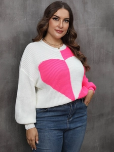 Detail of pink knitted heart pattern and soft texture on white crewneck sweater