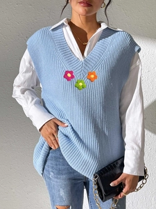 Gros plan sur le débardeur en maille bleu clair avec col en V et appliques florales en 3D