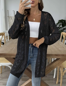 Detail of black open-knit crochet cardigan featuring intricate hollow-out floral patterns