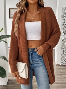 Detailed macro view of the coarse knit texture and ribbed cuff on the caramel cardigan
