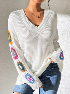 White V-neck sweater featuring vibrant hand-crocheted floral patchwork sleeves and casual fit