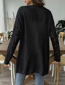 Close-up of the intricate hollow-out knit pattern on black long sleeve cardigan back