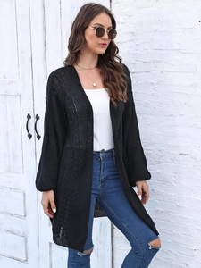 Close-up of black hollow-out knit cardigan showing detailed mesh texture and open stitch