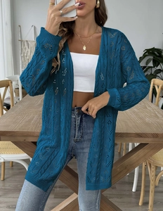 Detail of teal blue crochet knit cardigan showing intricate hollow wave pattern texture