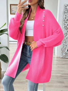 Close-up of neon pink knit cardigan featuring elegant pearl button details on the collar