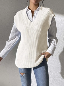Detailed macro view of white V-neck knitted vest showing ribbed texture and soft fabric finish