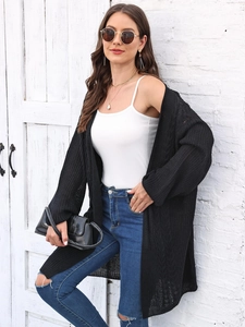 Close-up of black oversized knit cardigan featuring textured chunky knit stitch detail