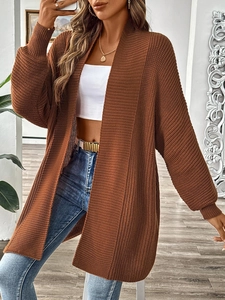 Close-up of caramel brown chunky knit fabric texture on a long loose women cardigan