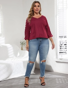 Detail of V-neck top with hollow out sleeves paired with distressed jeans and black sandals