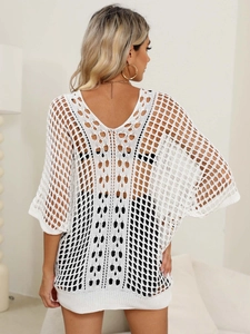Detailed view of white hollow crochet cover-up with textured knit and batwing sleeve