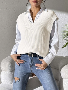 Women's V-neck white knit vest layered over a shirt with textured rib patterns