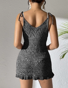 Détail de robe de plage en tricot noir et blanc avec dos nu et bretelles à nœuds