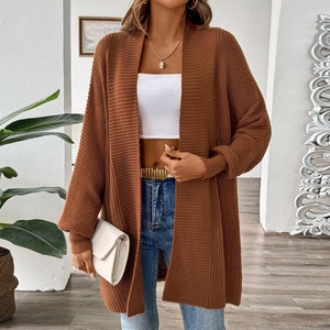 Close-up of brown knit cardigan texture with gold belt and white clutch details