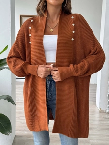 Detail of rust red knit cardigan with decorative white pearl beads on the collar lapel