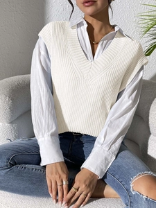 Close-up of white V-neck knit vest texture layered over a long-sleeve white shirt