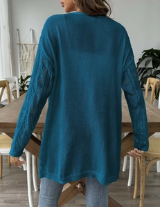 Detailed back view of teal knitted cardigan with openwork diamond crochet sleeves