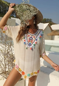Détails de broderies colorées et dentelle au crochet sur un cache-maillot de plage bohème