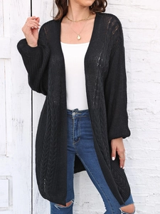 Detailed knit texture and classic cable patterns on a black longline cardigan sweater