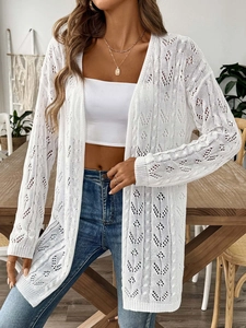 Close-up of white crochet cardigan featuring intricate hollow lace knitting and textures