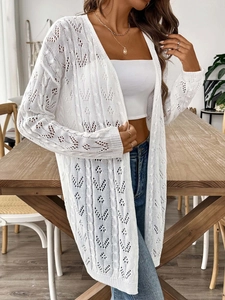 Detailed view of white crochet cardigan with intricate geometric hollow floral knit texture
