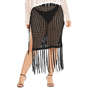 Detailed close-up of black crochet knit skirt with hollow grid pattern and long fringes