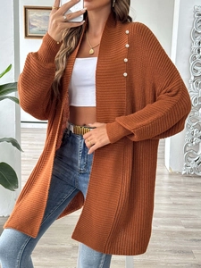 Detail of caramel knit cardigan featuring decorative white pearls on the neckline