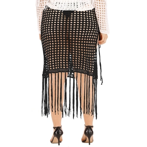 Macro view of black crochet knit skirt featuring hollow mesh pattern and long fringe trim