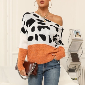 Detail of off-shoulder leopard print knit sweater with orange contrast sleeve and jewelry