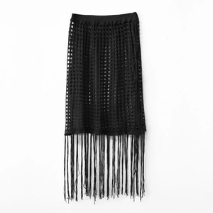 Detailed view of the black knit hollow-out beach skirt with long hanging fringe tassels