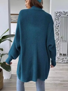 Back view of a loose oversized dark teal knit cardigan sweater with a cozy ribbed high neck