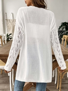 Detailed back view of white knit cardigan showing elegant crochet hollow-out sleeve design