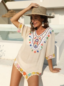 Gros plan sur une robe de plage bohème avec broderies colorées et détails en crochet