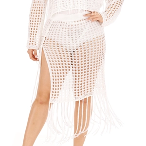 Detailed close-up of white crochet knit beach skirt featuring long tassels and mesh texture