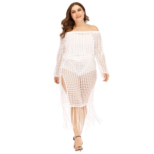 Detail of white crochet knit beach cover-up with long fringe and side slit texture