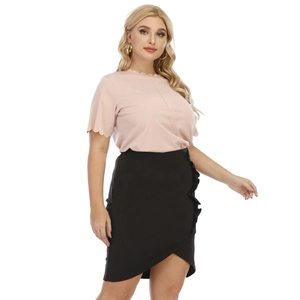 Detail of pink blouse with ruffle edges and black asymmetric skirt with side frills
