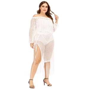Detail of white crochet knit beach skirt featuring hollow mesh design and long tassels