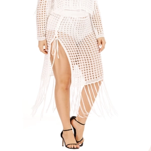 Detailed macro view of white crochet knit texture with high slit and long fringe tassels