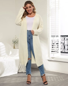 Detailed knit texture of a women's cream long cardigan styled with blue denim jeans
