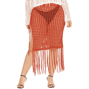 Close-up of rust-red crochet knit skirt with hollow-out mesh pattern and long fringes